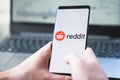 Russia Moscow 02.02.21 Mobile phone with logo of Reddit traders in hand. Community of financiers pump stock prices. Playing on Royalty Free Stock Photo