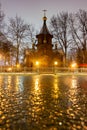 Old wooden russian church. Streets after rain, wet asphalt Royalty Free Stock Photo