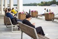 2022-07-17. Russia. Moscow. Northern River Station. A woman is sitting on a bench with a phone in her hands on the embankment.