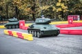 Children ride on little model of Russian T34 tank at the mini training ground. Young boy drives toy tank. Children attraction in Royalty Free Stock Photo