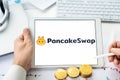 Russia Moscow 06.05.2021 Pancakeswap logo.Cryptocurrency decentralized exchange DEX, tablet.Trading blockchain platform to swap,