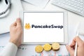 Russia Moscow 06.05.2021 Pancakeswap logo.Cryptocurrency decentralized exchange DEX, tablet.Trading blockchain platform to swap,