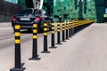 Russia Moscow 2019-06-17 parking limiter black round pillows with yellow stripes between roadway and sidewalk on background car