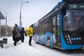 13.02.2021, Russia, Moscow. Passengers of urban land transport get on the bus at the bus stop. Winter, snowfall