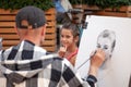 Russia Moscow 2019-06-17 Street Artist Draws Sketch Portrait of a beautiful girl. Street painter draws portrait of girl