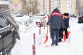 Russia Moscow 13.02.2021 Street cleaners, men clean snow from road, sidewalk with large shovels. City winter weather Royalty Free Stock Photo