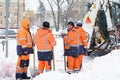 Russia Moscow 13.02.2021 Street cleaners,men clean snow from road,sidewalk with large shovels.Tractor,snow removal Royalty Free Stock Photo