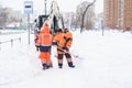 Russia Moscow 13.02.2021 Street cleaners,men clean snow from road,sidewalk with large shovels.Tractor,snow removal Royalty Free Stock Photo