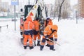 Russia Moscow 13.02.2021 Street cleaners,men clean snow from road,sidewalk with large shovels.Tractor,snow removal