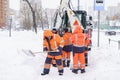 Russia Moscow 13.02.2021 Street cleaners,men clean snow from road,sidewalk with large shovels.Tractor,snow removal