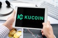 Russia Moscow 05.05.2021. Tablet with logo of cryptocurrency stock exchange Kucoin, China. Crypto coins company, service for