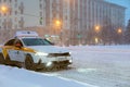 12.02.2021 Russia, Moscow. A taxi car against a snow-covered road. Cyclone, blizzard on the road.