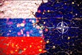 Russia and nato flags painted over cracked concrete wall.And lava flows behind. russia vs nato war