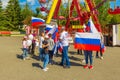 a group of children with Russian flags and sports posters in the park on a summer day. Russian text: Russia Forward, Victory, Hig