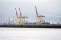 Russia, Novorossiysk, April 11, 2021: A cargo port pier with portal cranes and a cluster of containers.