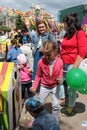 children and parents paint street figures houses in the Park at the city festival