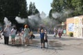 Russia, children and parents relax in the fog water vapor in the park refreshes in summer