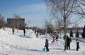 funny children ride on an ice slide in a park in Siberia in winter