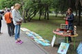 girl artist sells paintings to buyers exhibition on the street