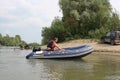 Russia, male fishermen sail in a motor boat on the river in summer for tourism and recreation