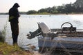 A male poacher catches fish with a net on a river boat for prohibited fishing