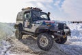 Offroad SUV `Jeep Wrangler` 4x4 with off-road training rides in winter on snow