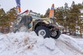 Ld Russian offroad SUV gaz69 4x4` quickly goes lifting snow in winter on a hill with flags of the finish Royalty Free Stock Photo