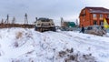 Russian white SUV `UAZ Patriot` with its nose raised high drives into a snowdrift