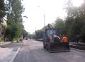 Russia, Novosibirsk, 10 may 2015: a tractor with a bucket road technics workers made the new asphalt to repair roads in the city