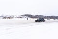 Russian light old low car `VAZ Zhiguli` quickly goes sideways through the snow in the drift on the road