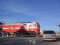 Russia, Novosibirsk, October 14, 2012: closed railway crossing with raised barriers passing locomotive car stopped misses train