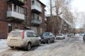 parked cars in winter near a residential building on the driveway