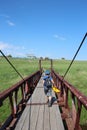 a small child one boy walks on an iron bridge in the summer across the river Royalty Free Stock Photo