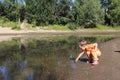 a small child plays in the water with ducks in a pond in nature in summer Royalty Free Stock Photo