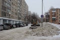 tractor grader removes snow from the road in winter in the city on the street