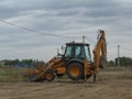 tractor grader stands on raised supports performs earthworks road equipment at a construction site