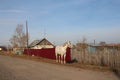 Russia, a white horse walks in the village on a farm near the fence