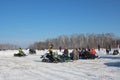 In winter, men ride a snowmobile with transport in Siberia, viewers watch