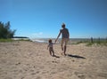 A woman with a child walking on the beach by the sea mom and son