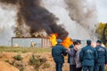 Russia - October 2019: Employees of the Russian Ministry of Emergency Situations MES on the background of burning buildings