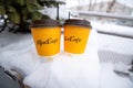 Russia, Orenburg, 02.02.2022: two yellow cups for coffee from McDonald`s cafe restaurant stand in the snow in winter. Warm drinks