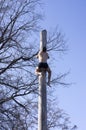 Russia. Penza/ A man climbing a high pole