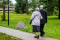 Russia, Priozersk, August 2016: An elderly couple together goes under the arm on the wooden walkway