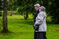 Russia, Priozersk, August 2016: An elderly couple together goes under the arm on the wooden walkway