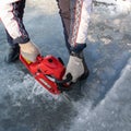 Russia, River Volga Kama - Jan 17th 2020. Man carving an ice hole entry with a motor saw chainsaw for ice scuba diving