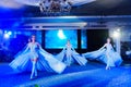 Girls dancers in beautiful stage costumes dancing at a festive banquet.