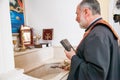 Russia, Rostov-on-Don - May 30, 2014: An Armenian priest with a cross and a bible performs the rite of baptism over the font
