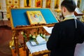 A priest reads a prayer book at baptism in the Orthodox Church.