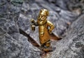 Russia, Ruskeala - August 3, 2023: Bronze figurine of a gnome on a stone