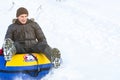 Russia, Ryazan 05 Jan 2019: happy man sliding down hill on snow tubes over winter natural background